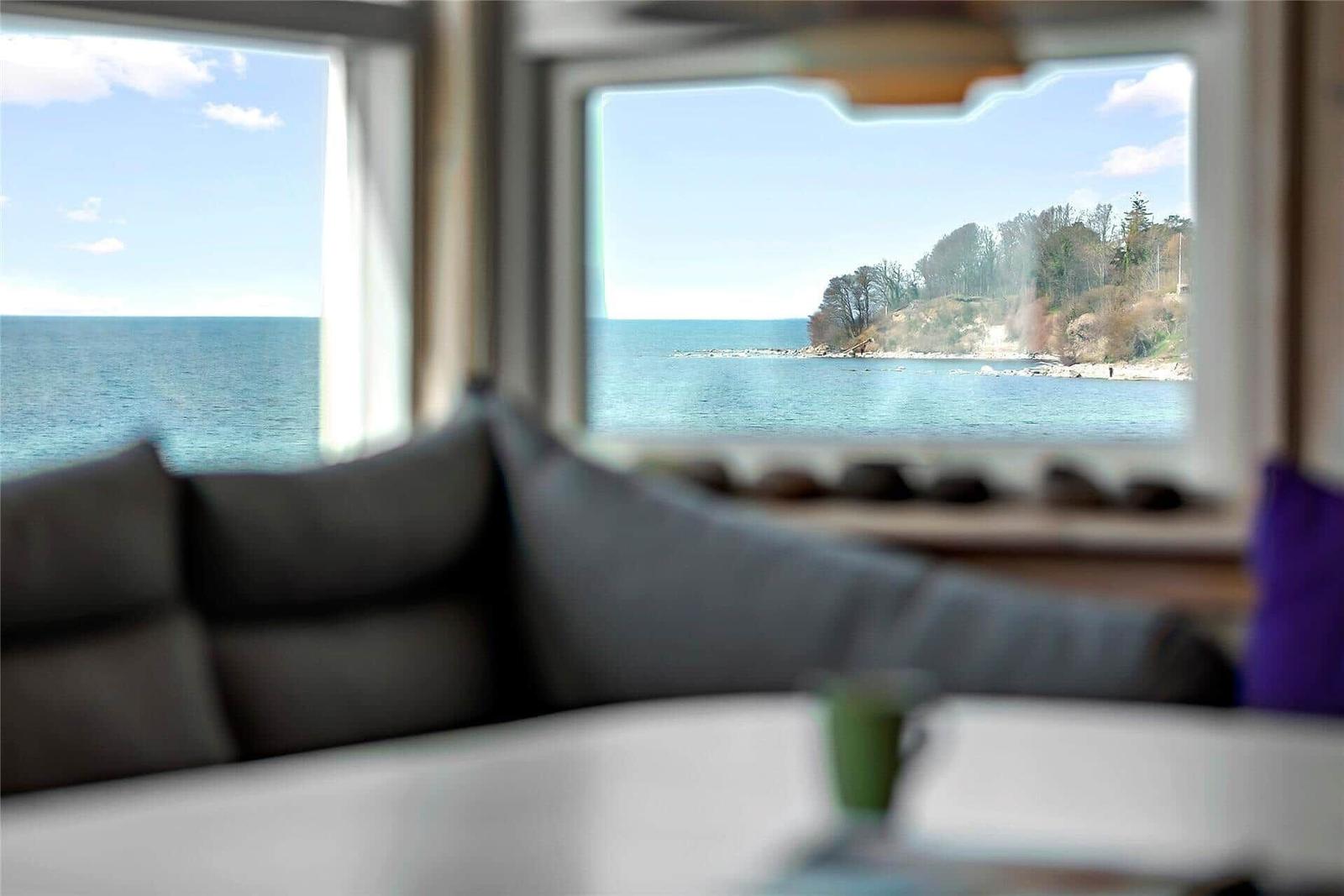 From the living room, you can see the sea and a wooded coastline.