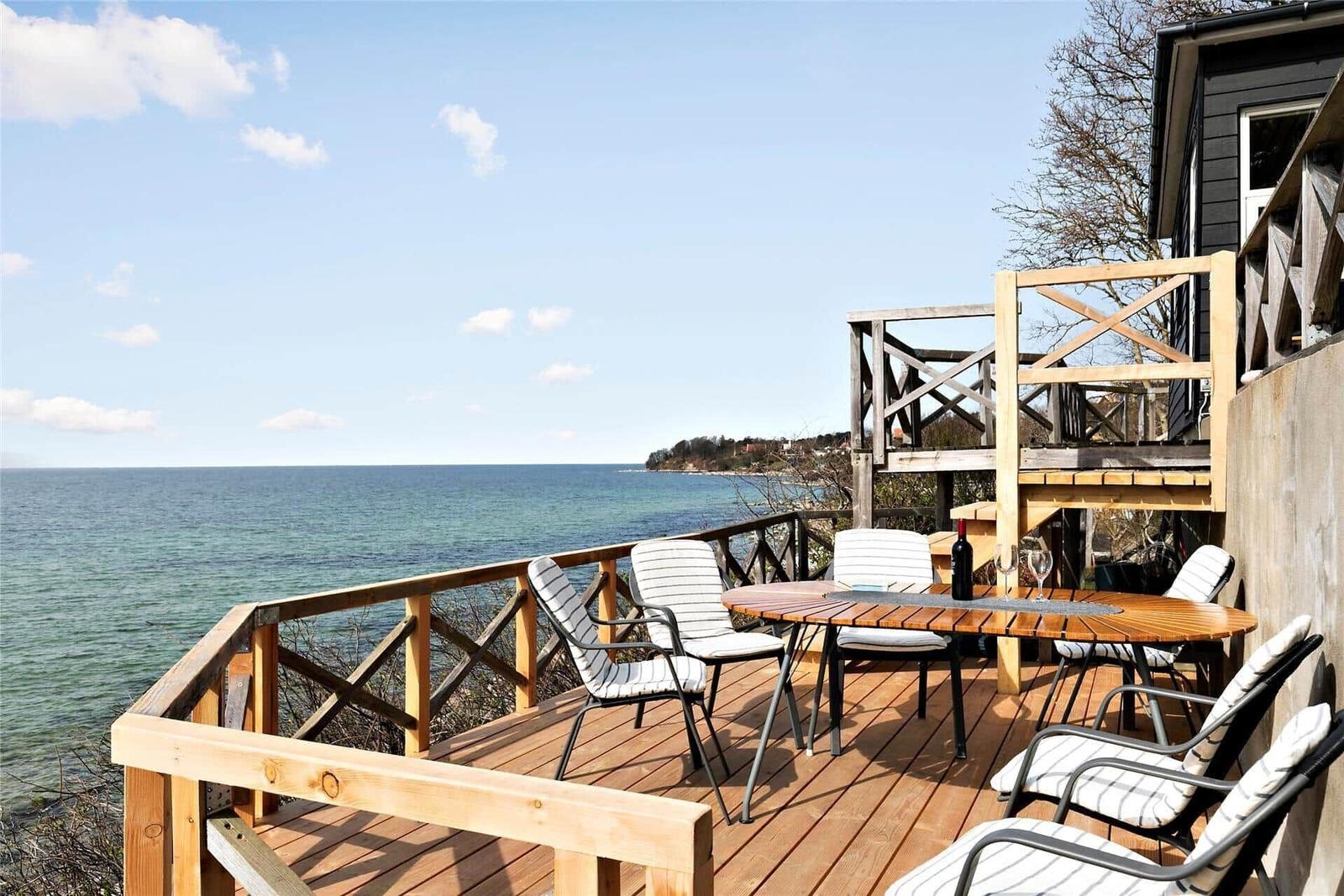 Deck with table and chairs overlooking the sea at the coast.