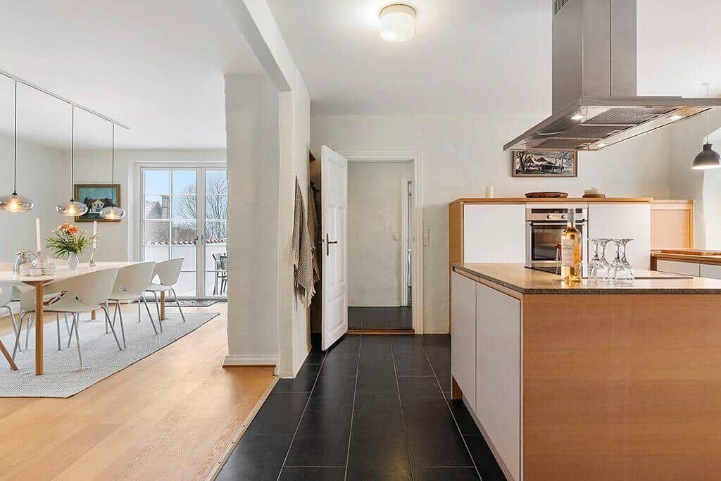 Kitchen with wooden surfaces and dining area with table and chairs.