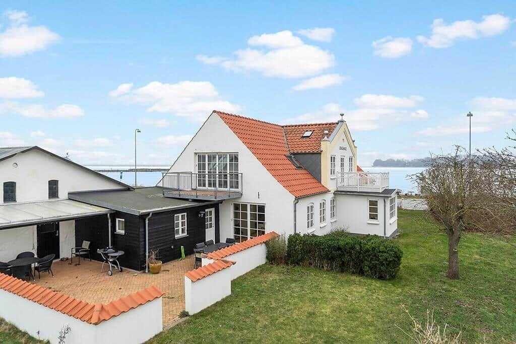 House with terrace, barbecue area, and view of water.