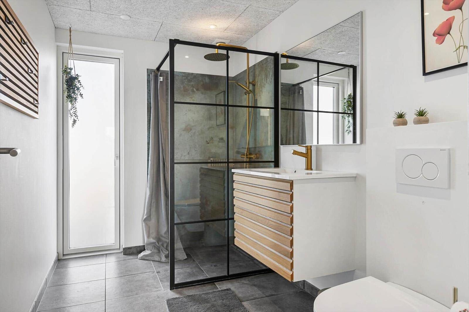 Bathroom with shower stall, sink, and toilet. Wooden and metal accents.