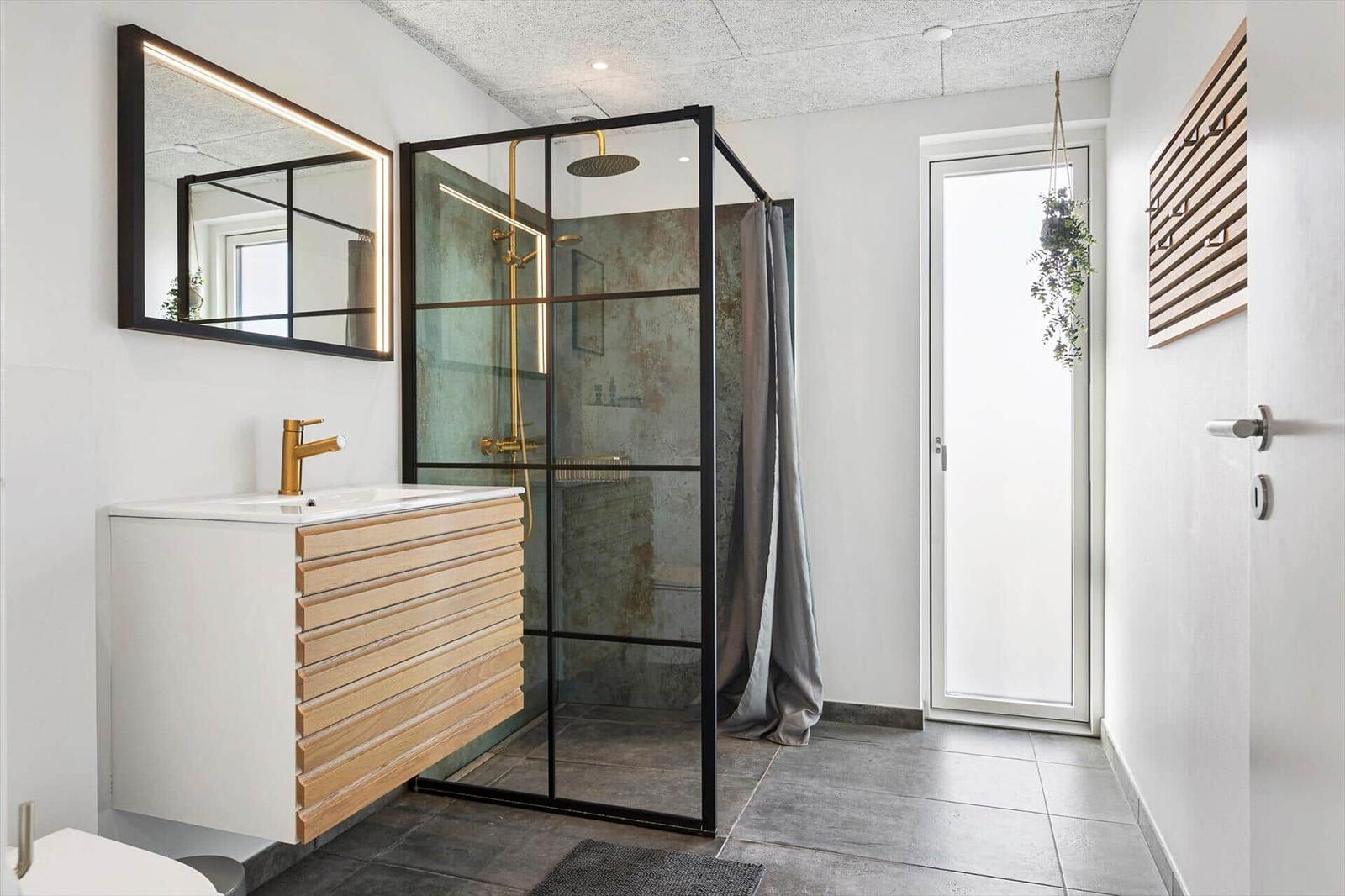 Bathroom with shower enclosure, sink, and mirror.