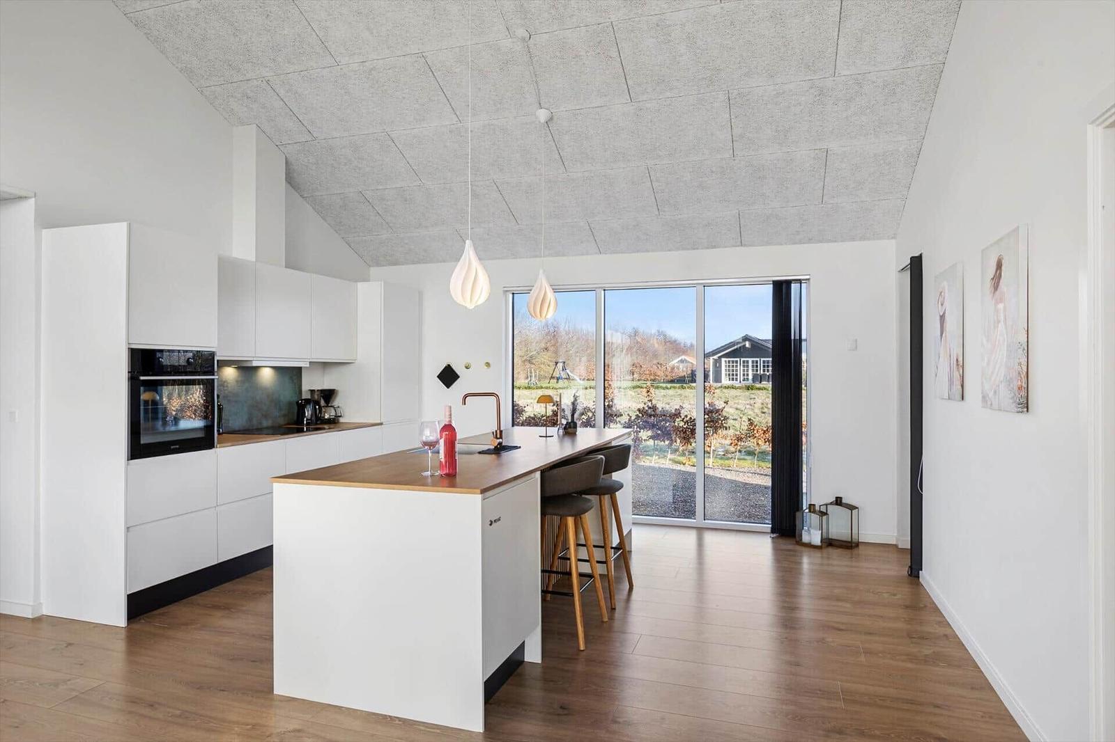 Kitchen with island, hardwood floor, and large window to garden.