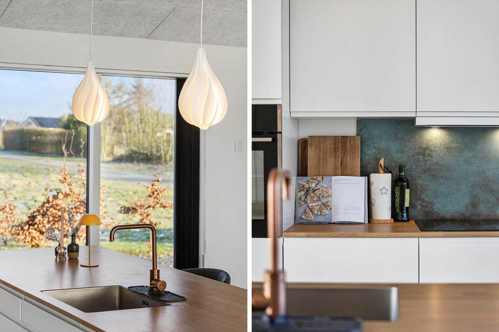 Kitchen with wooden surfaces, white cabinets, and modern pendant lights.