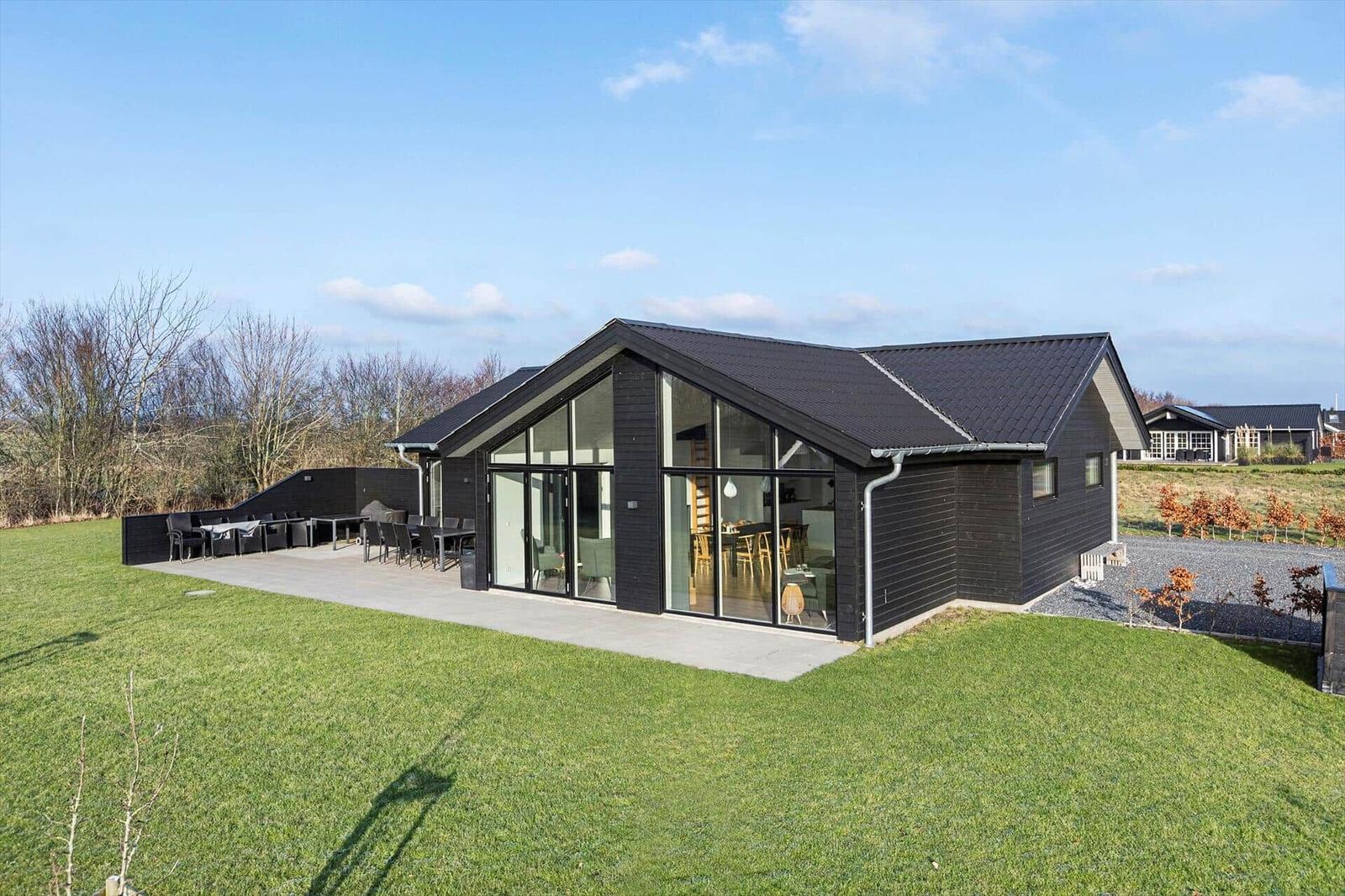 Modern house with large glass area and terrace in the green.