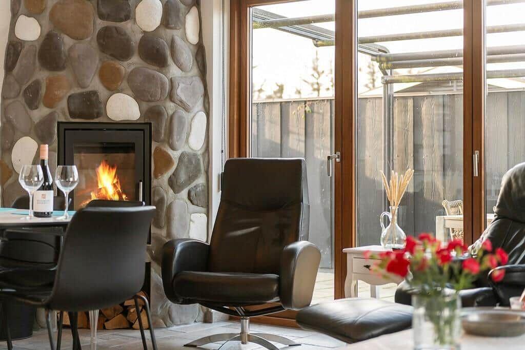 Raum mit Kamin, Sitzgelegenheiten und Terrassentür
