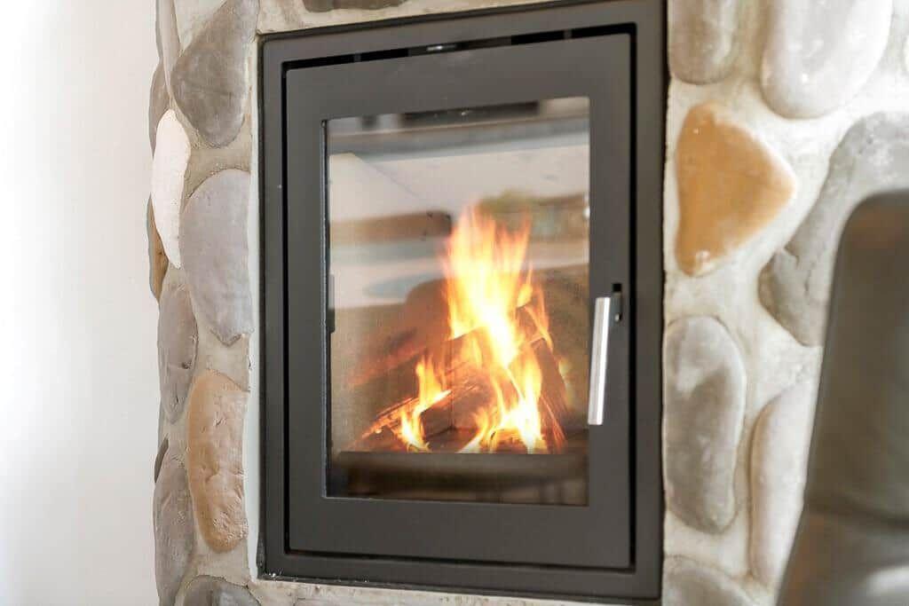 Kamin mit Steinmauer und brennendem Holzfeuer