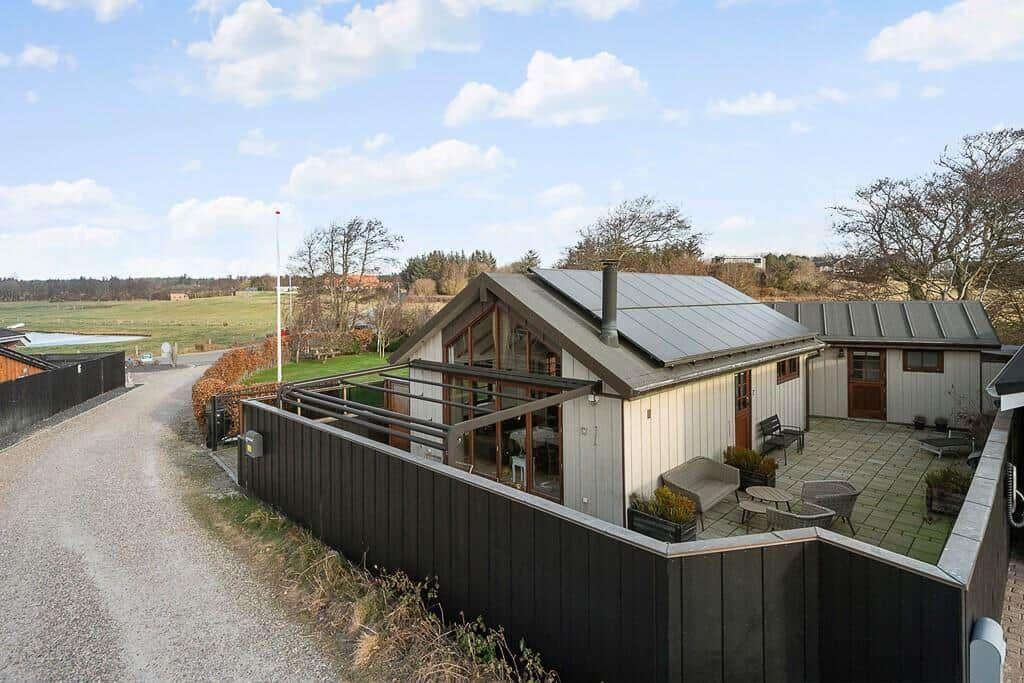 Moderne Ferienhaus mit Terrasse und Garten. Blick auf Felder und Bäume.