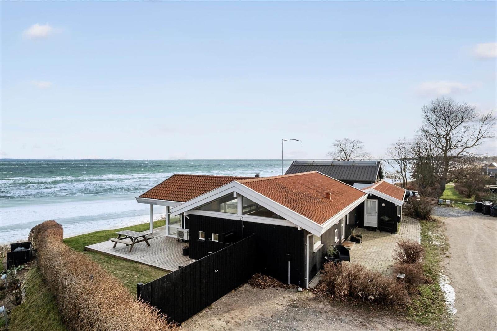 Black beach house with terrace and sea view.