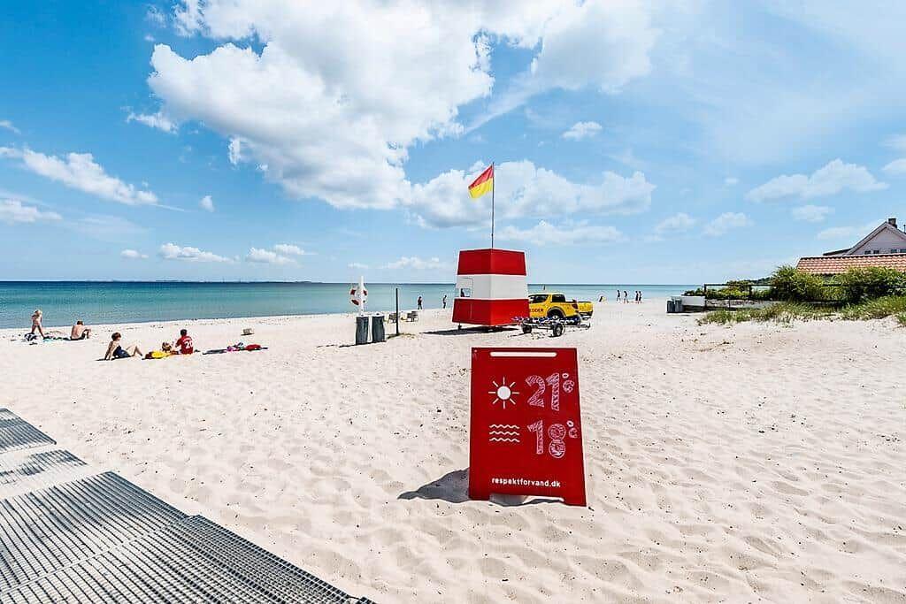 Beach with bathing water, lifeguard station, and temperature sign