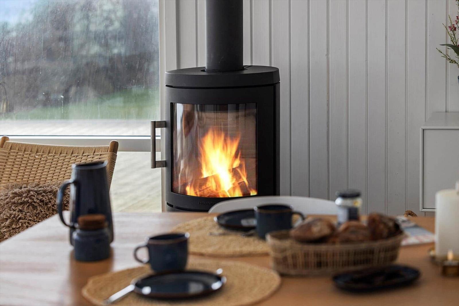 Dining table with fireplace and view of outdoor area.