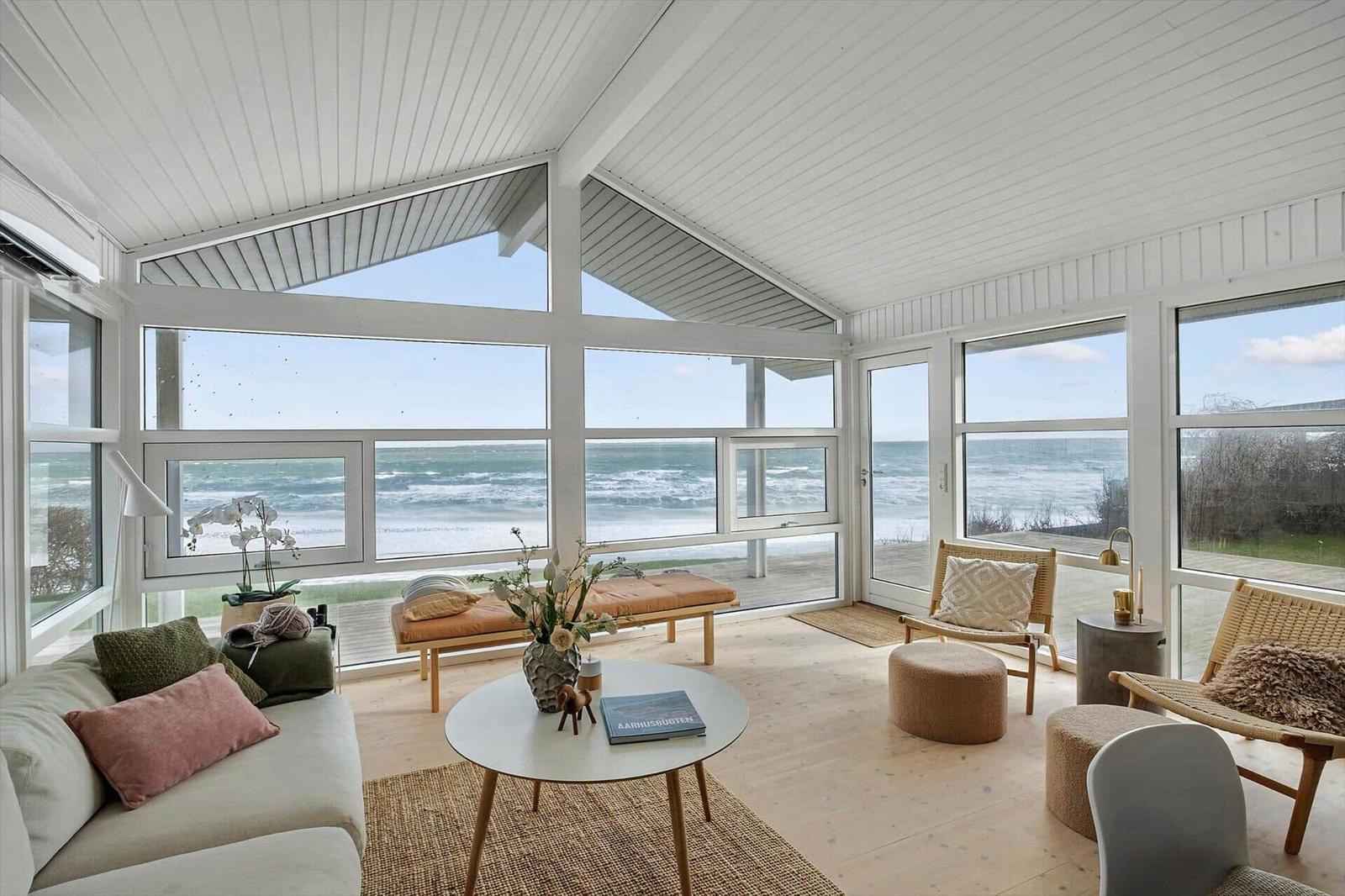 Living room with large windows overlooking the sea and beach.