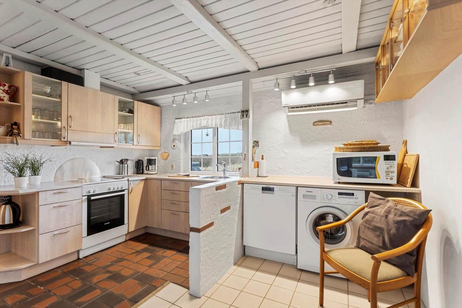 Kitchen with washing machine, dishwasher, and microwave