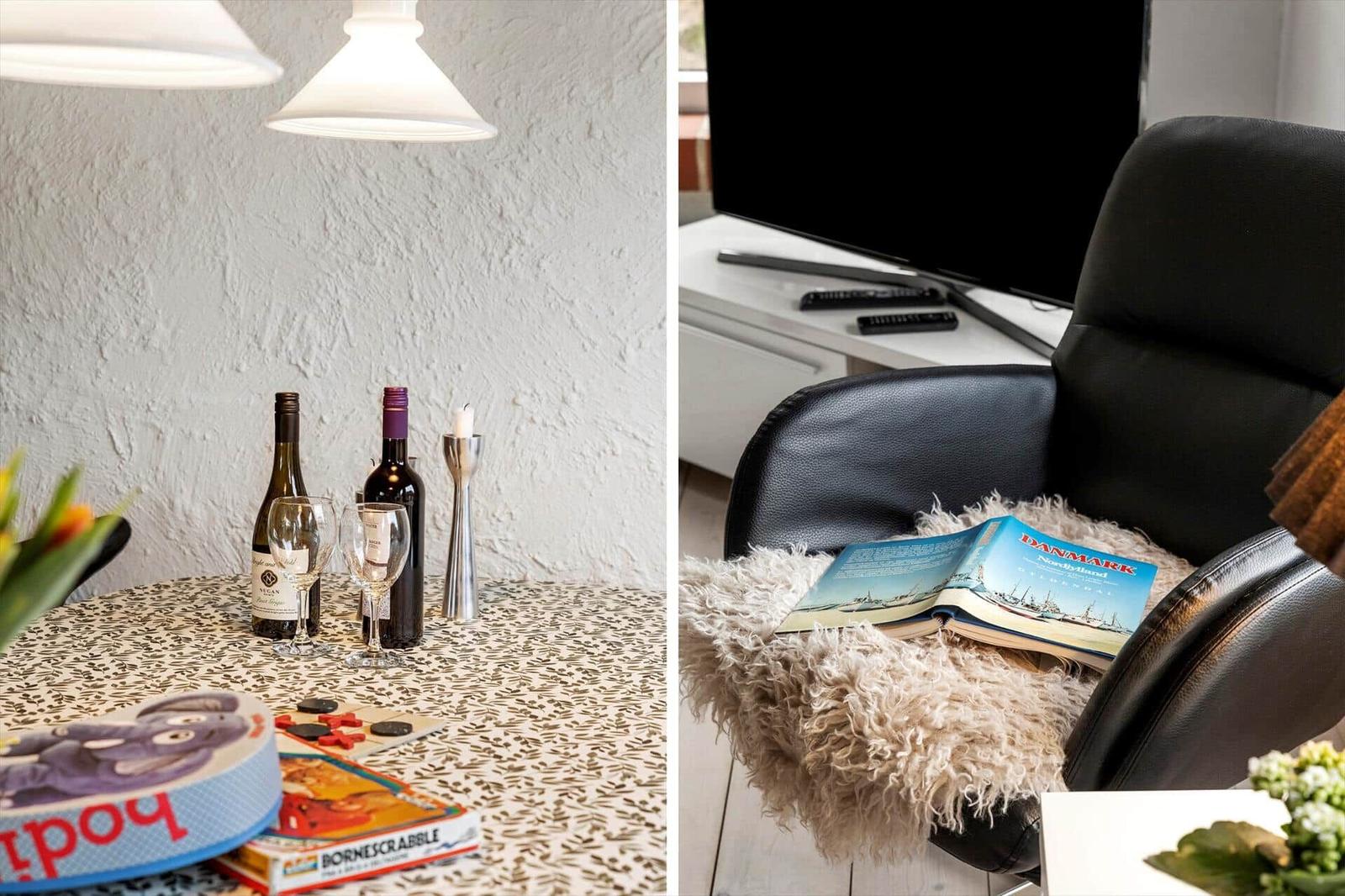 Dining table with wine bottles and board games. Black chair with book and fur blanket.