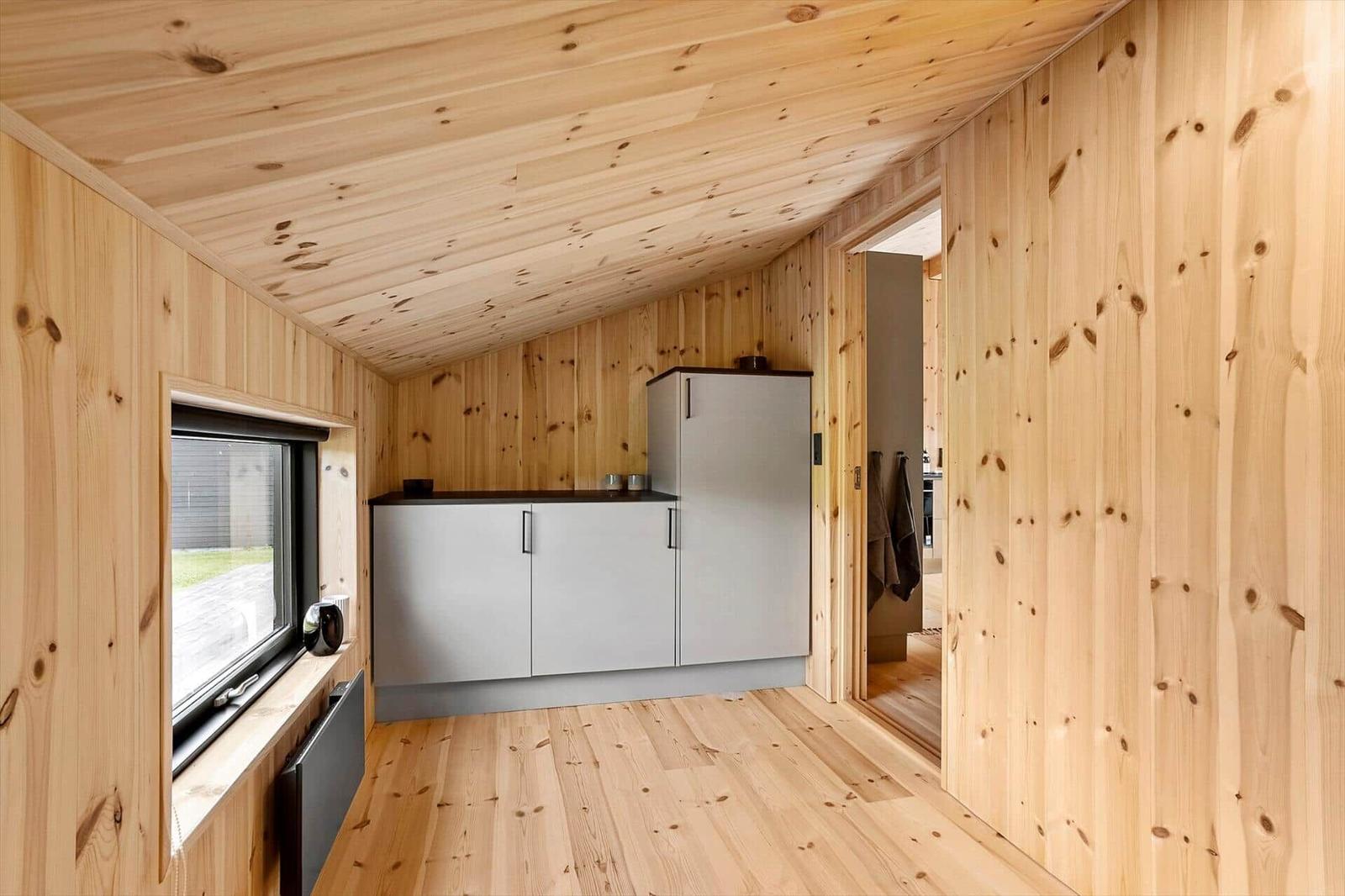 Kitchen with wooden walls, window, and cabinets