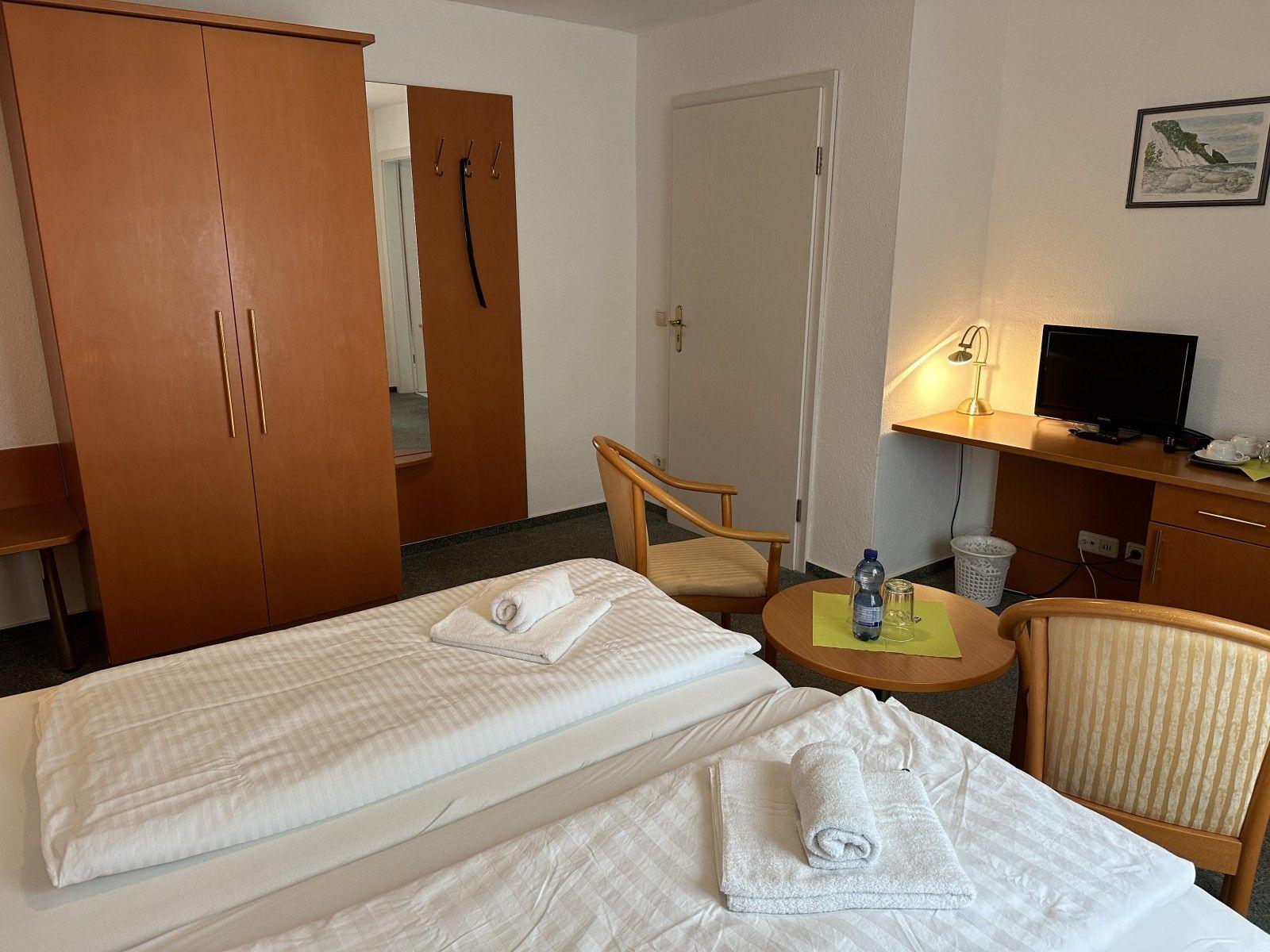 Room with double bed, desk, TV, and wardrobe.