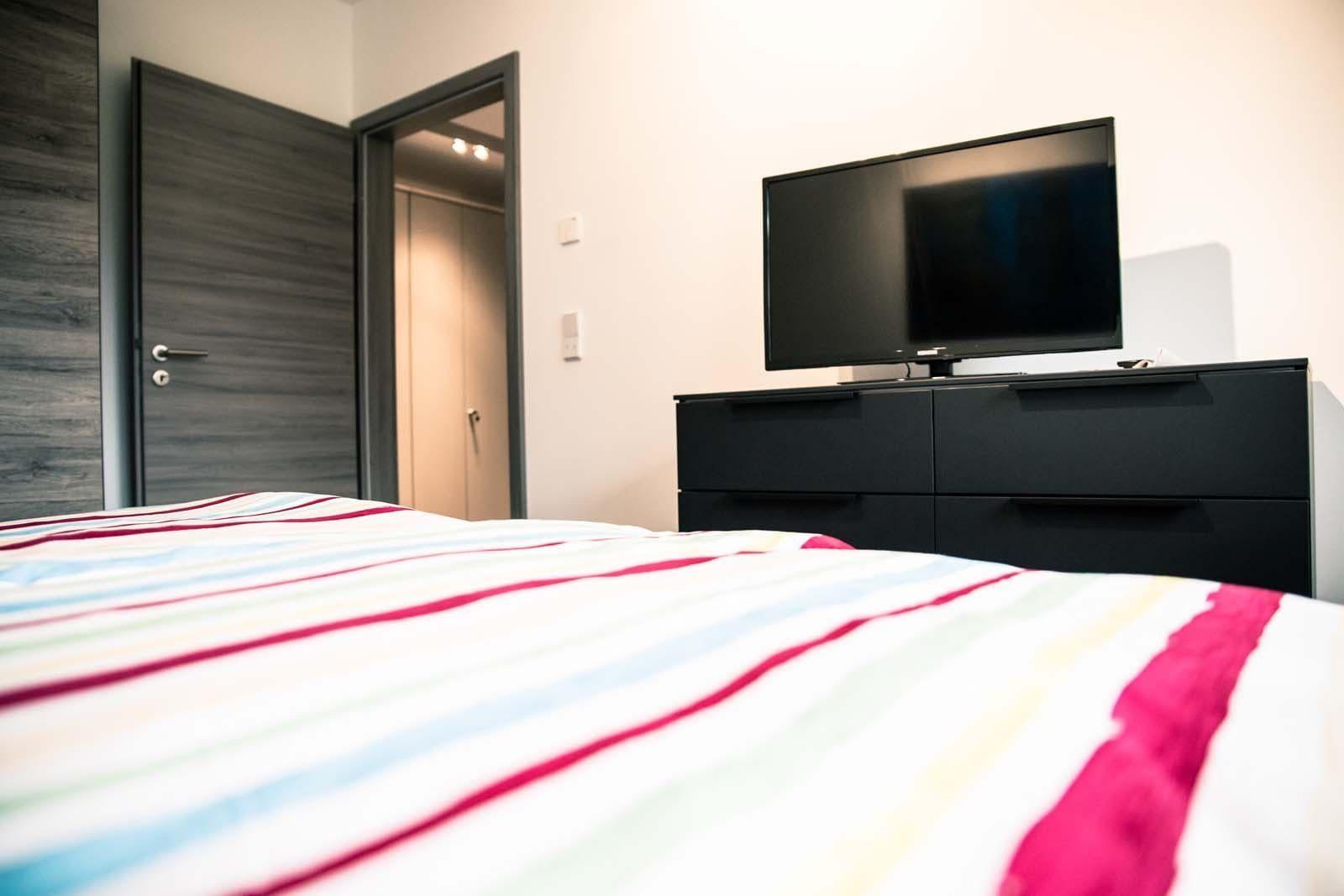 Schlafzimmer mit Bett, TV und Schrank