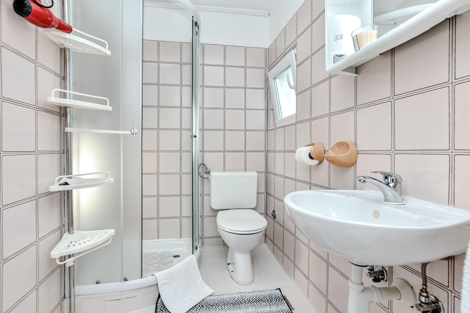 Badezimmer mit Dusche, Toilette und Waschbecken