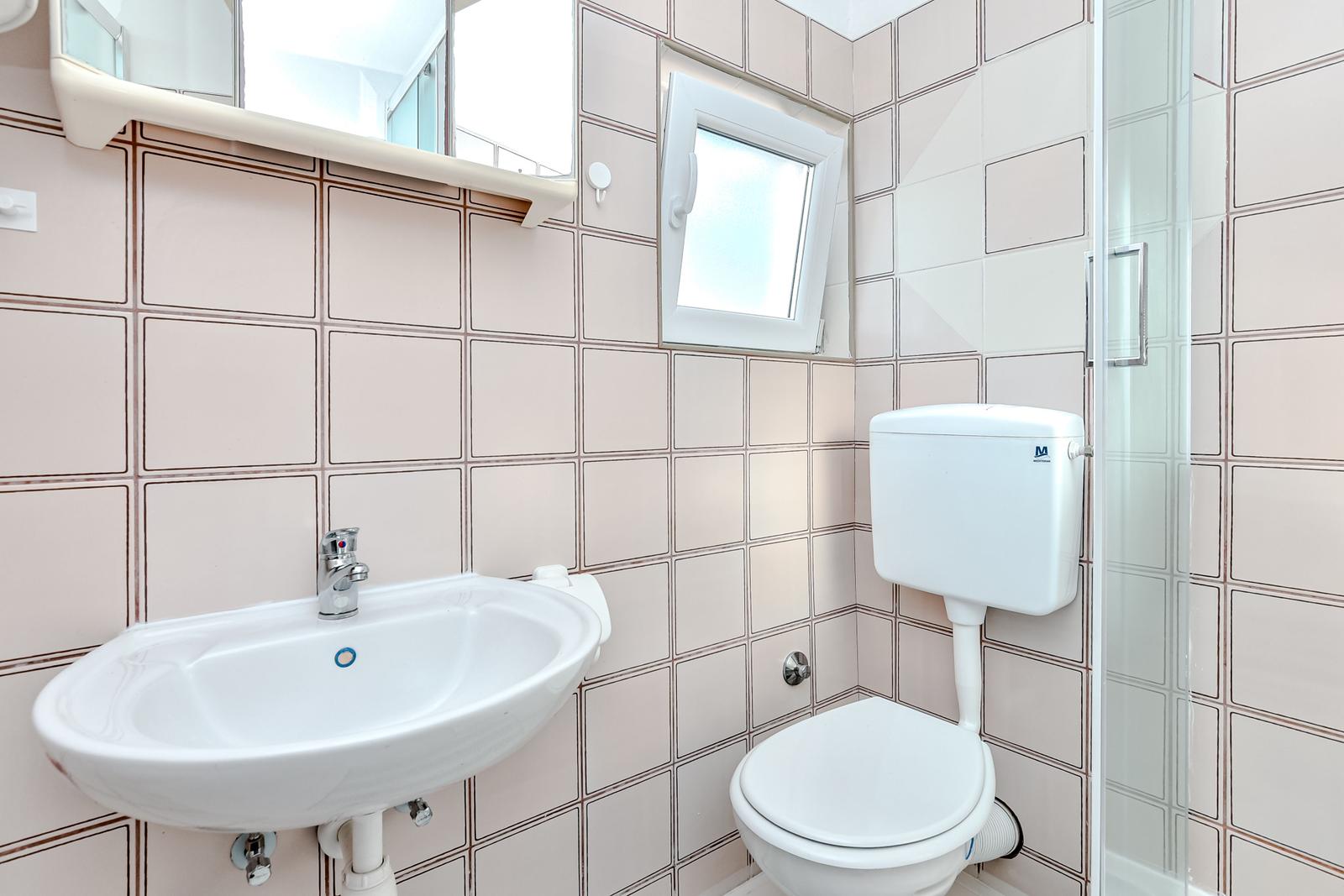 Badezimmer mit Waschbecken, Toilette und Dusche