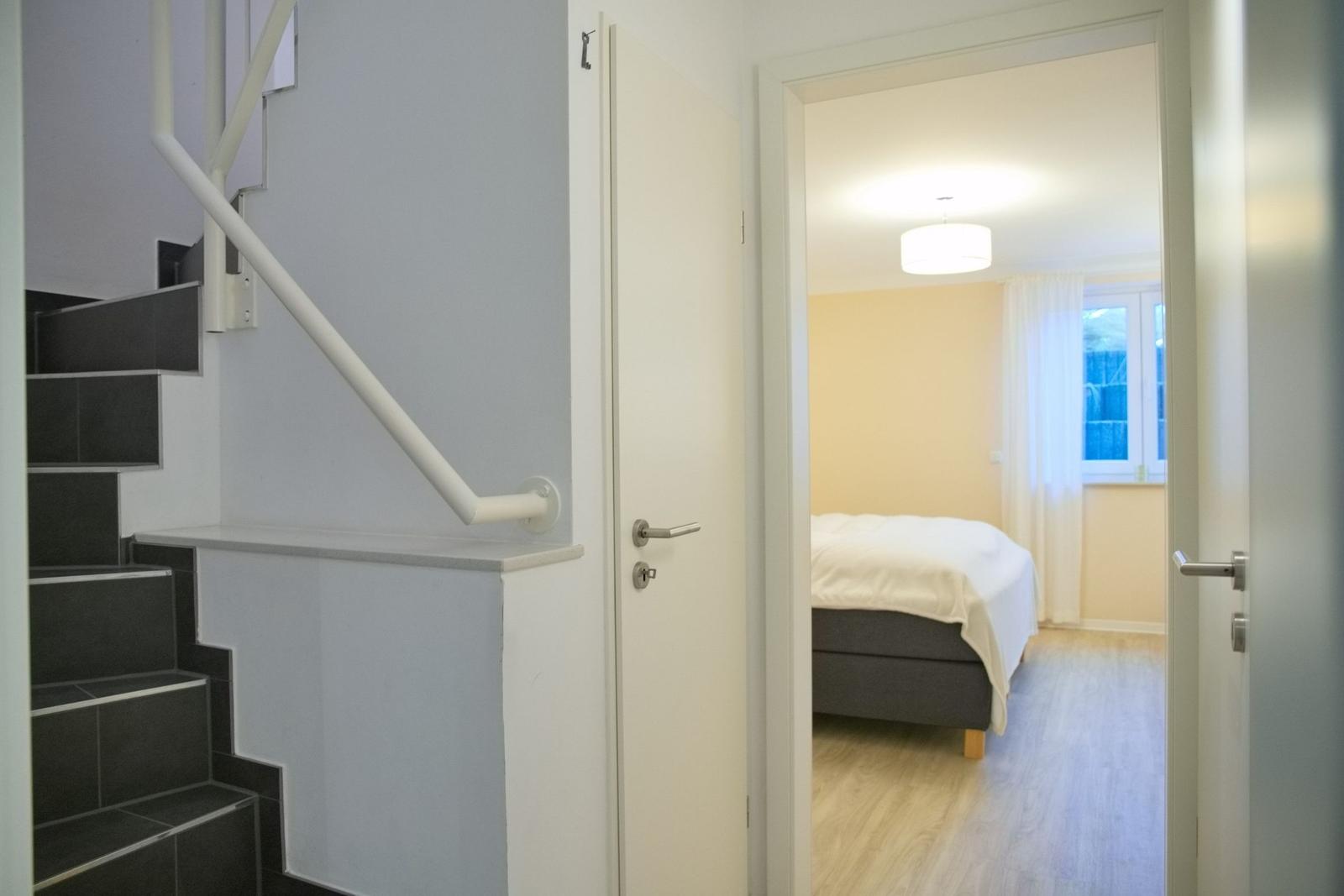 Treppenhaus mit Schlafzimmer im Hintergrund