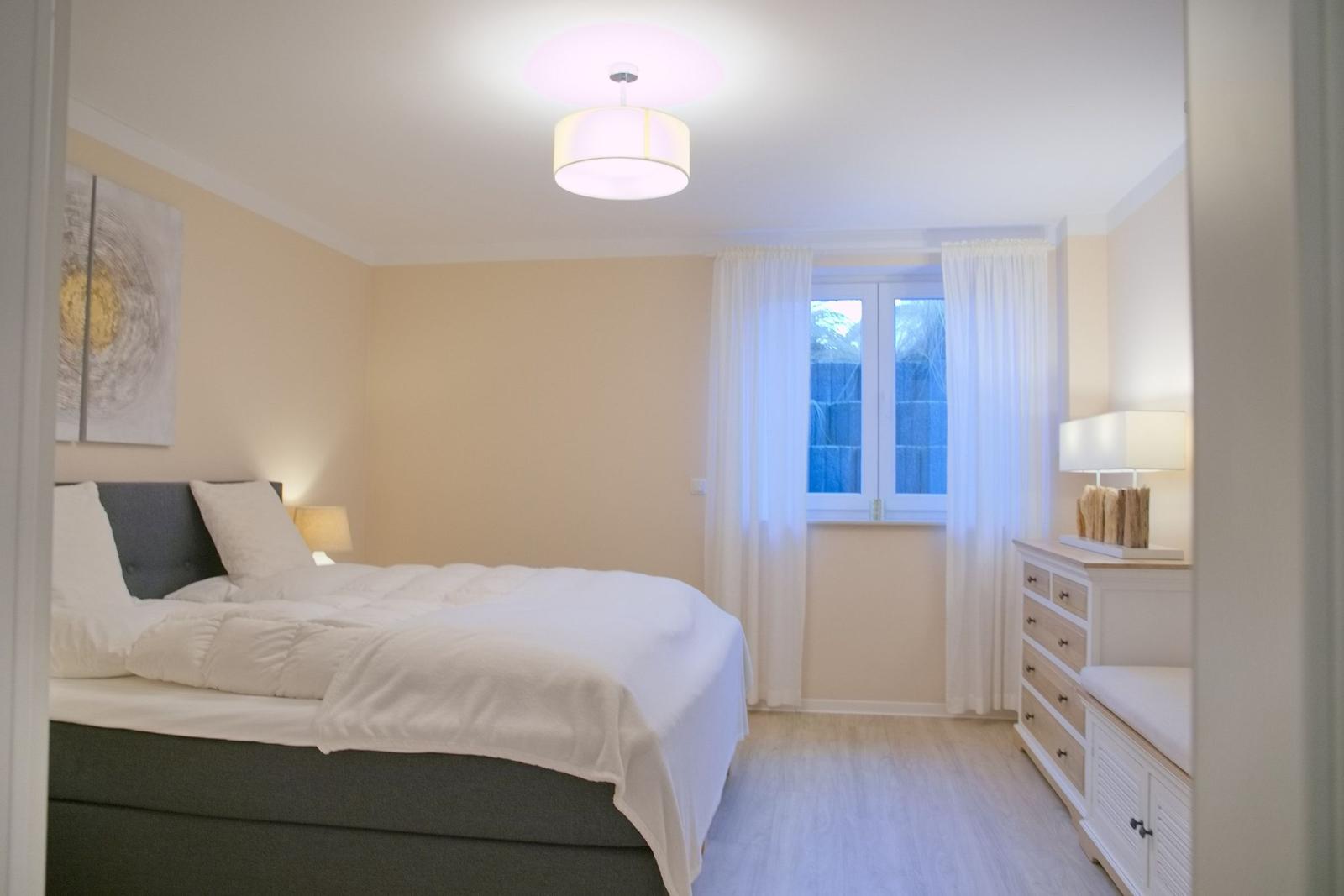 Schlafzimmer mit Bett, Fenster und Schrank.