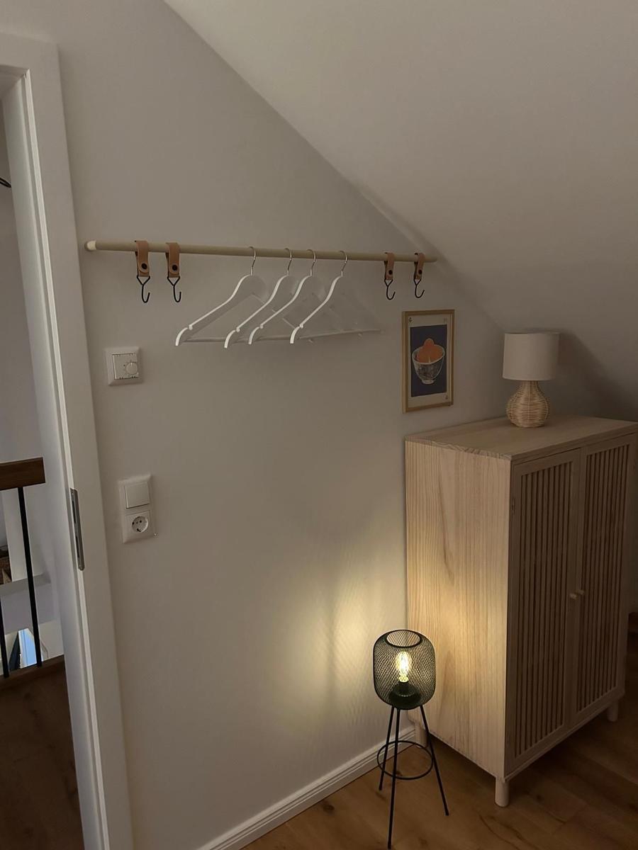 Schlafzimmer mit Kleiderständer, Schrank und Stehlampe unter Dachschrägen
