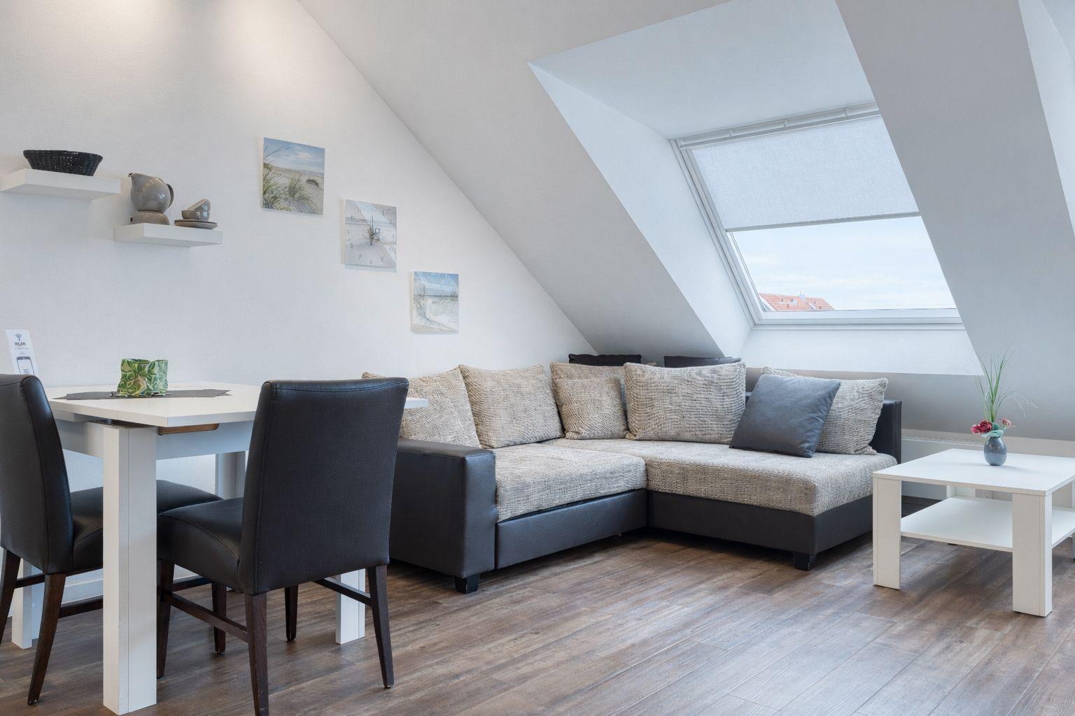 Wohn- und Essbereich mit Sofa, Tisch und Fenster