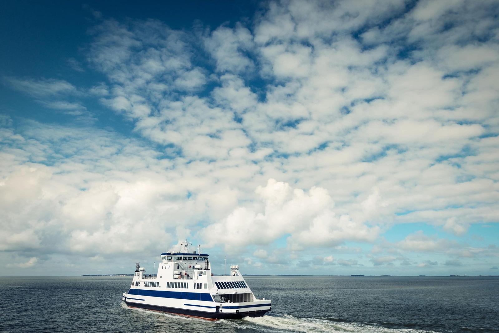 Ferries fährt über das Meer unter einem bewölkten Himmel.