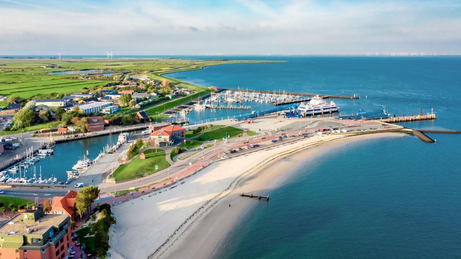 Hafen mit Booten, Strand und grünen Flächen am Wasser