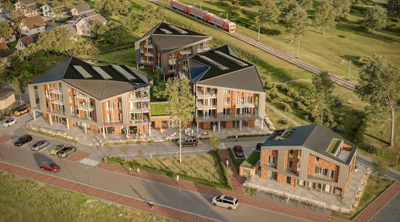 Moderne Wohnhäuser mit Terrassen und grünen Flächen. Bahnlinie und Parkplatz sind sichtbar.