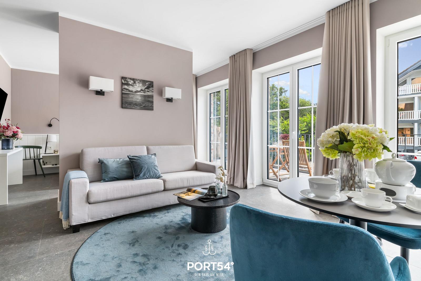 Wohnzimmer mit Sofa, Esstisch und Blick auf Balkon