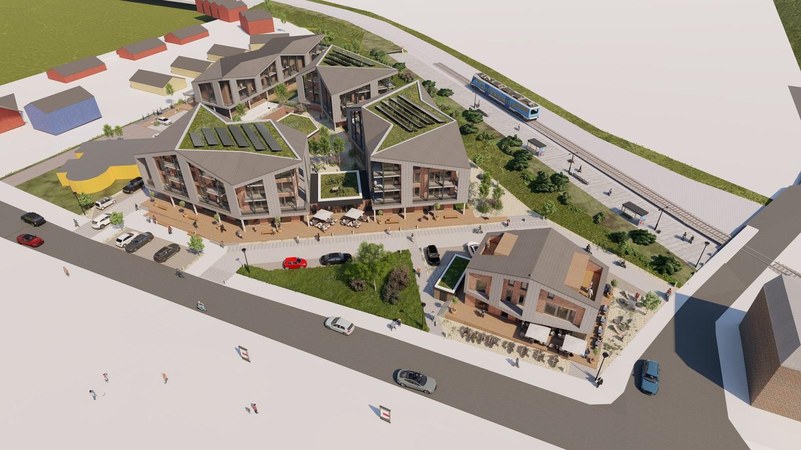 Modernes Gebäude mit grünen Dächern und Solaranlagen. Umgebung mit Straßen, Bäumen und Gleisen.