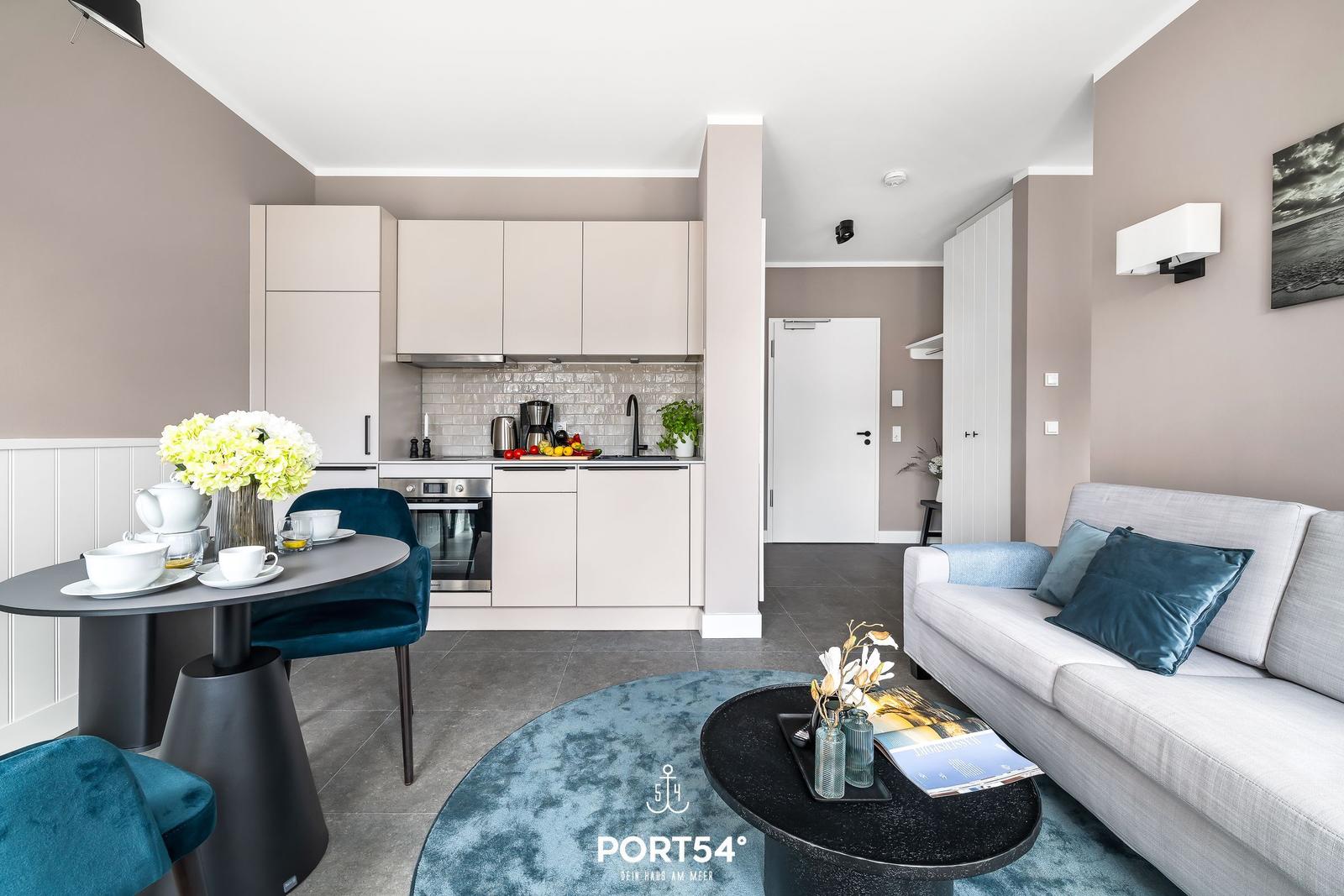 Wohnküche mit Essbereich und Sofa. Moderne Einrichtung und Küchenzeile.