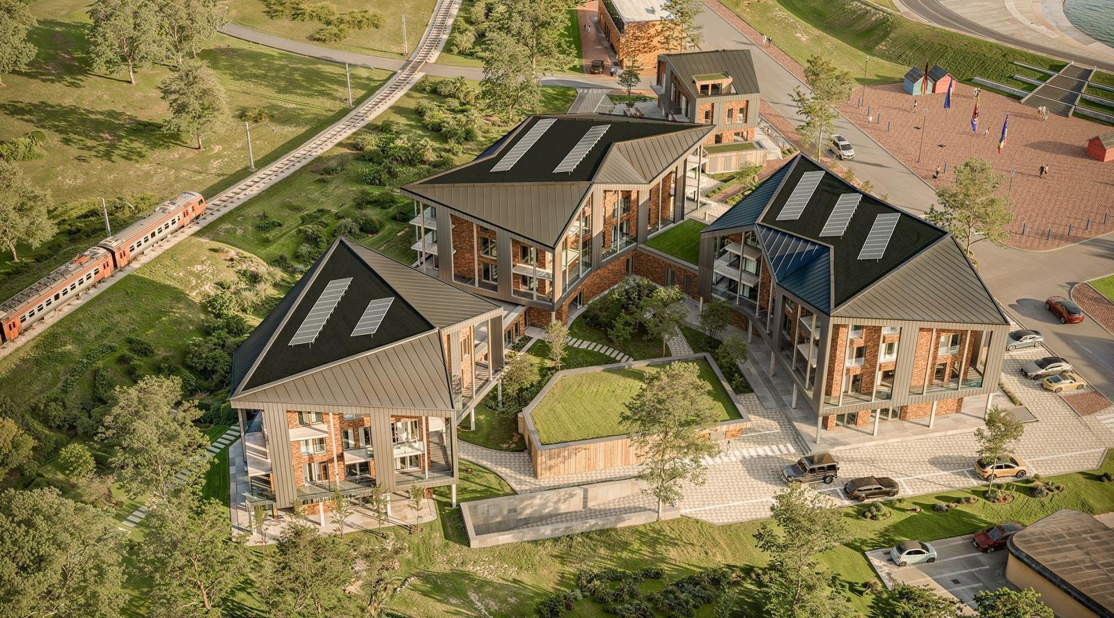 Modernes Gebäude mit Solaranlagen und grünen Dächern in ländlicher Umgebung.