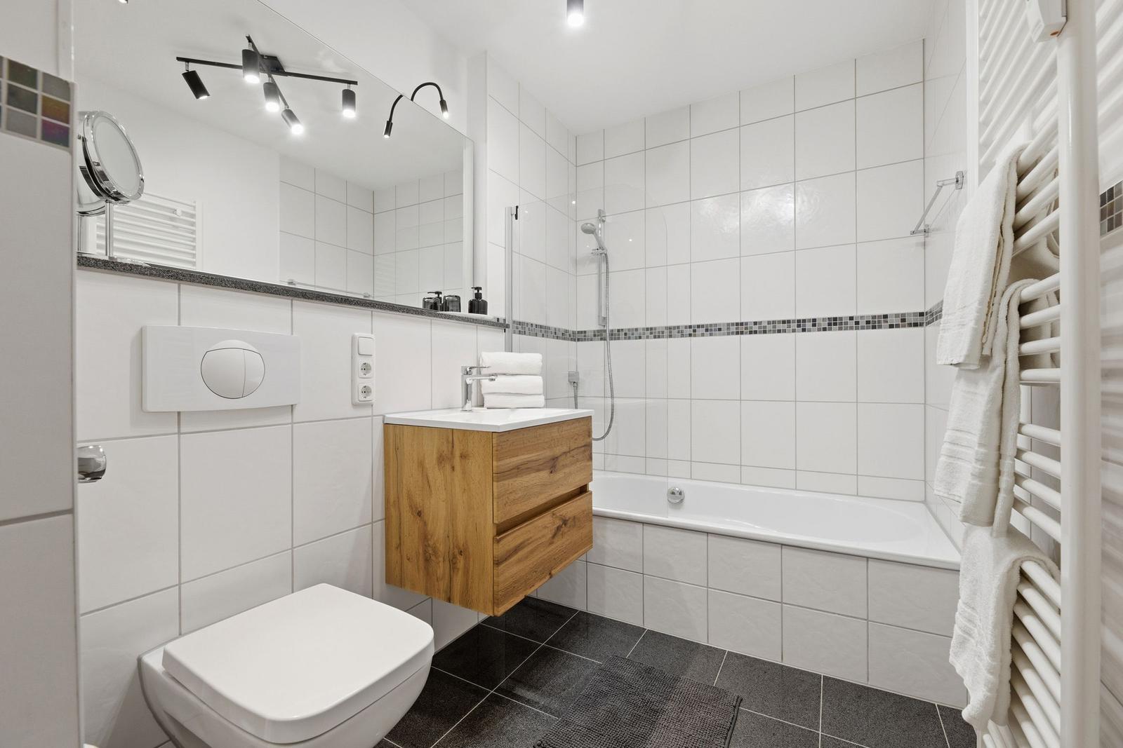 Badezimmer mit Badewanne, Dusche, Waschbecken und Toilette.