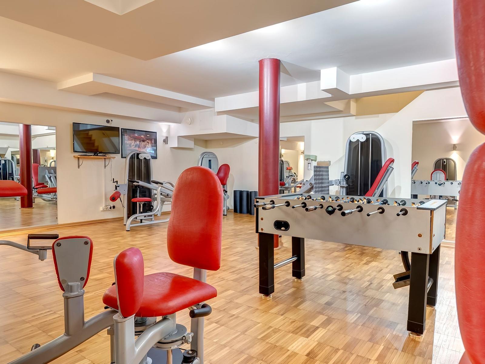 Fitnessraum mit Trainingsgeräten und Tischfußball