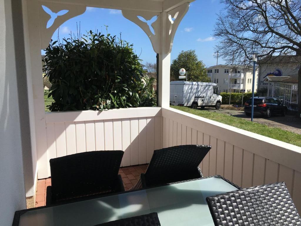 Terrasse mit Tisch und Stühlen, Blick auf Grün und Straße.