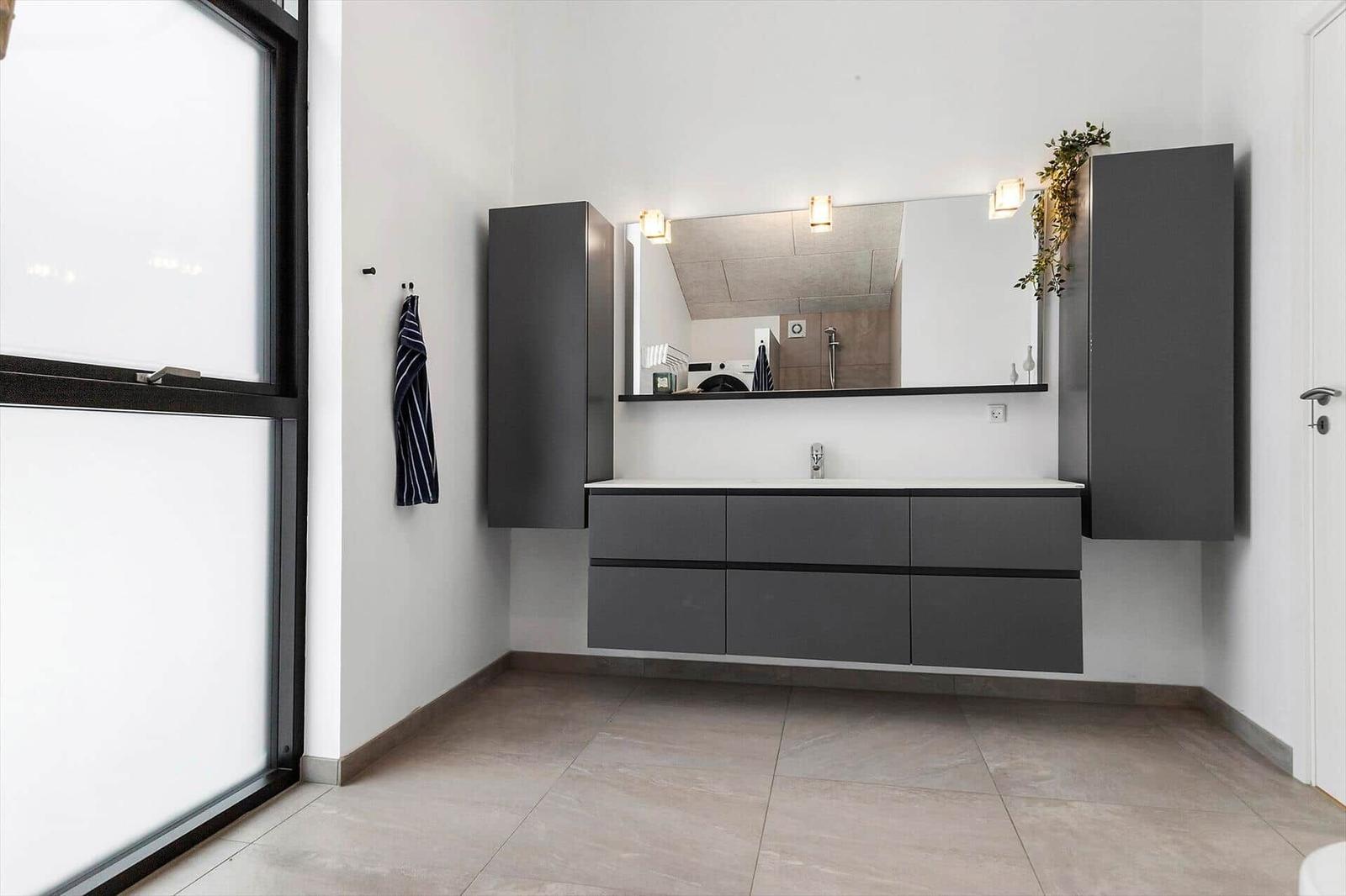 Moderne Badewanne mit Spiegelschrank und Waschmaschine