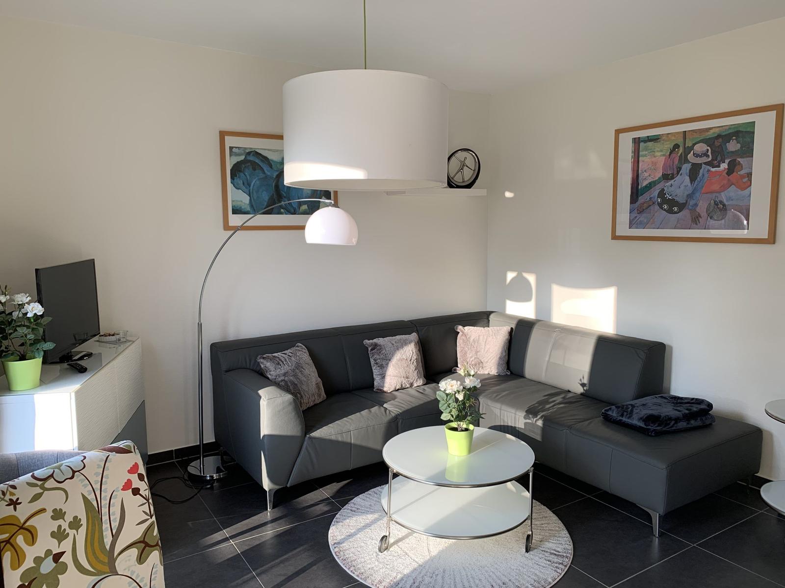 Wohnzimmer mit Sofa, Couchtisch und Stehlampe.