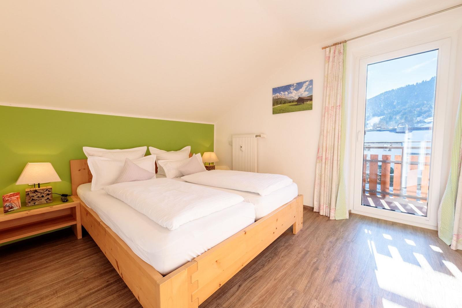 Schlafzimmer mit Doppelbett, Balkon und Bergblick.