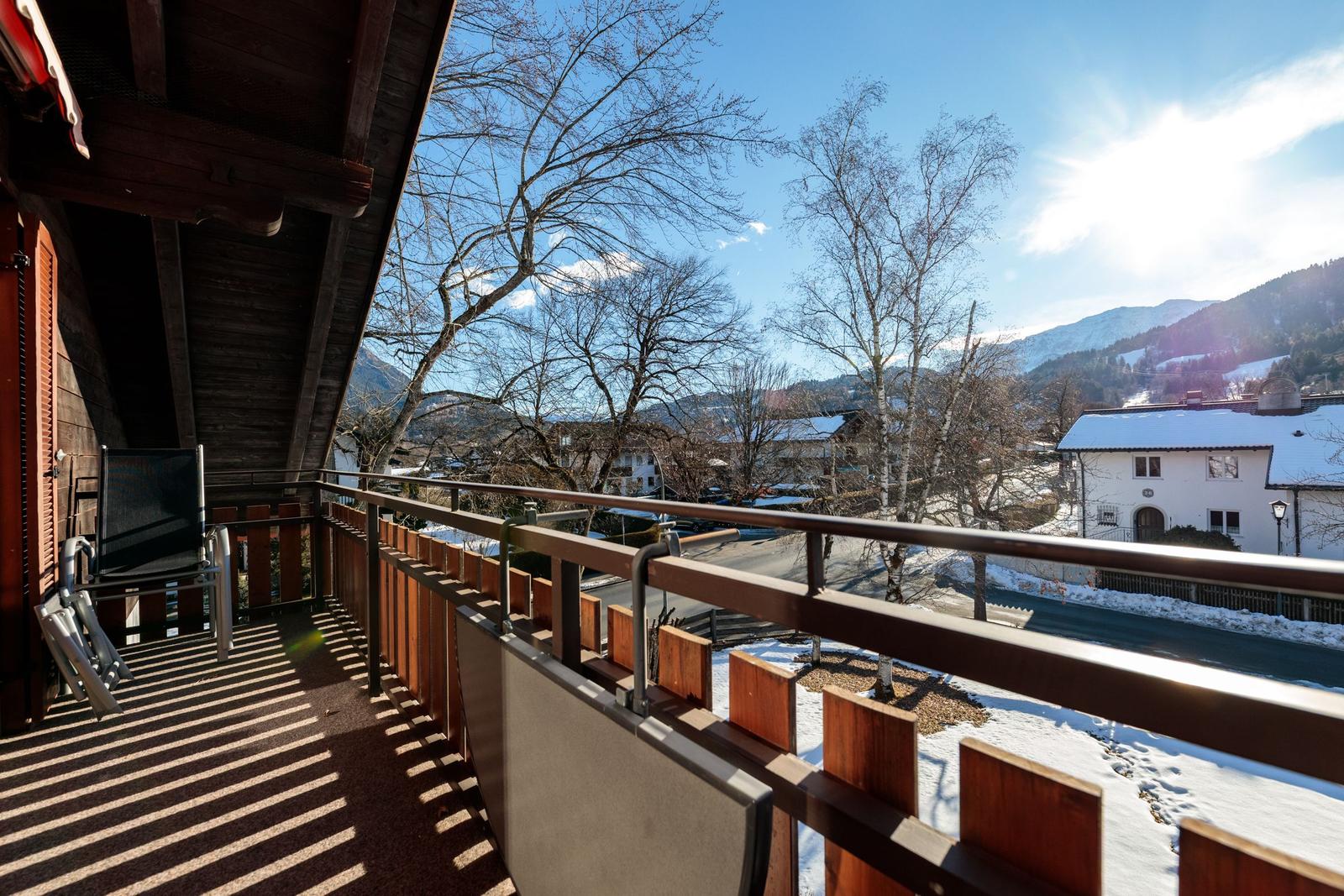 Terrasse mit Blick auf verschneite Berge und Häuser