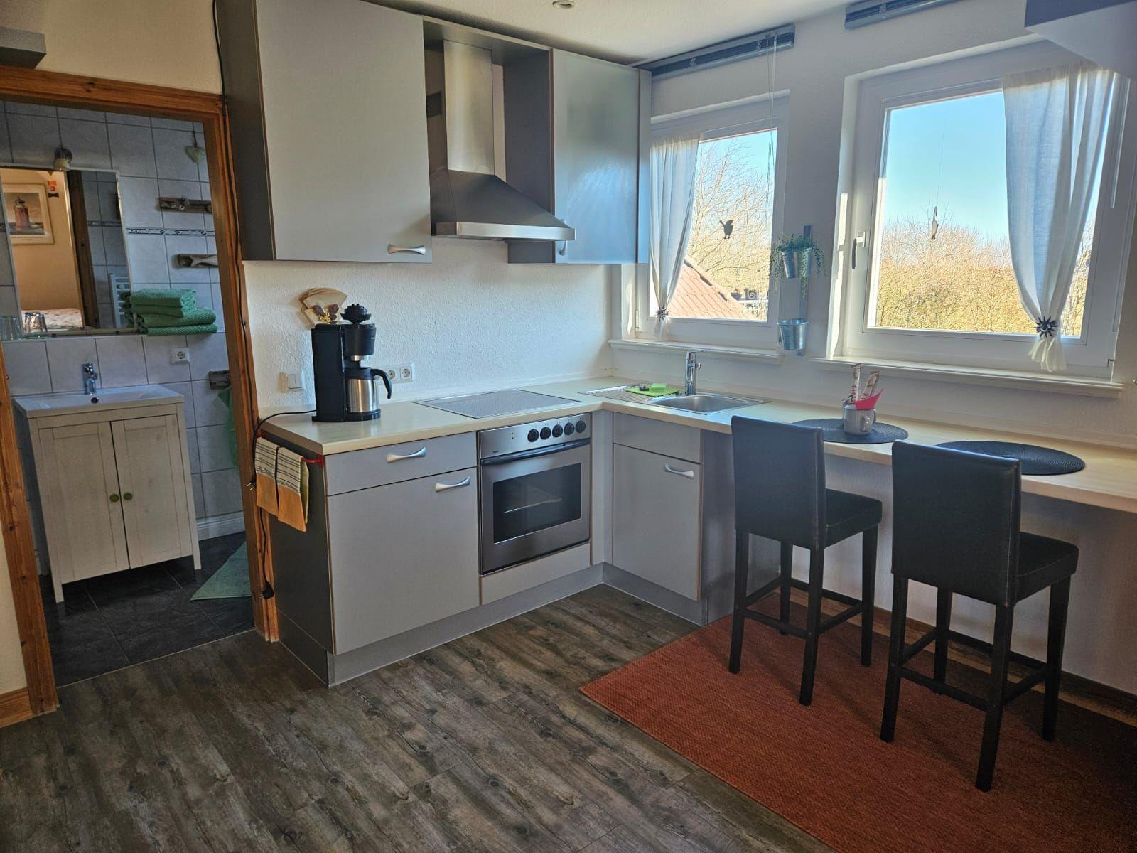 Küche mit Arbeitsplatz, Spüle, Herd und Fenster