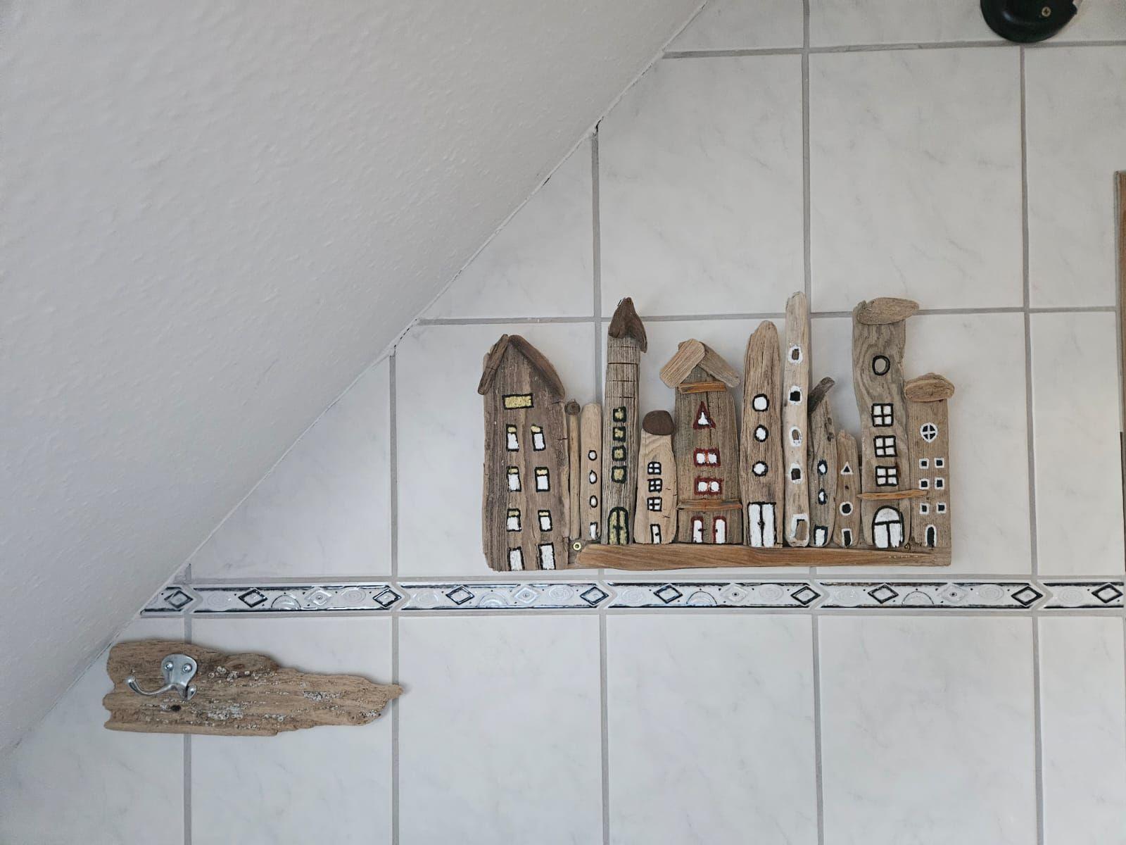 Driftwood-Hausdekoration an einer Fliesenwand mit Mosaikstreifen