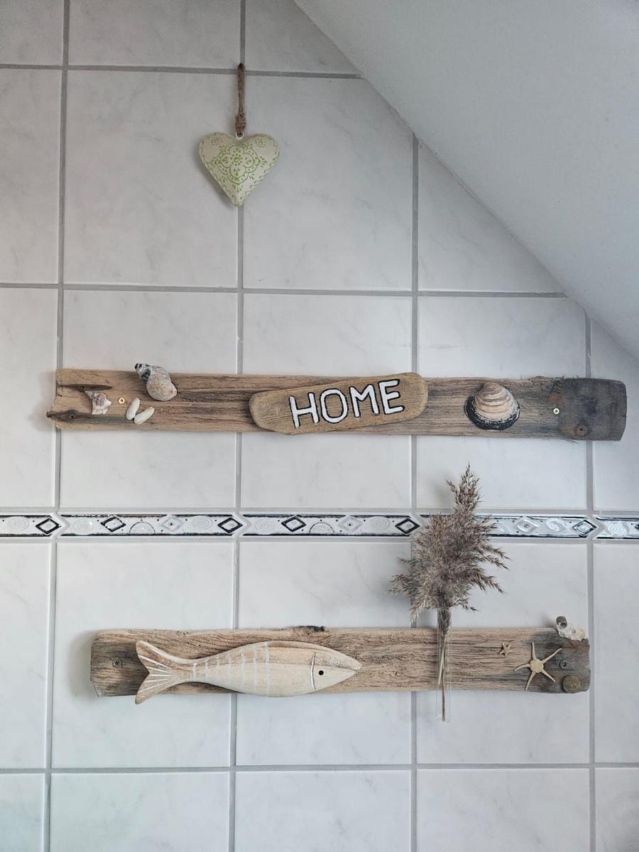 Wand mit Holzdekorationen, Muscheln und einem Herz an der Decke.