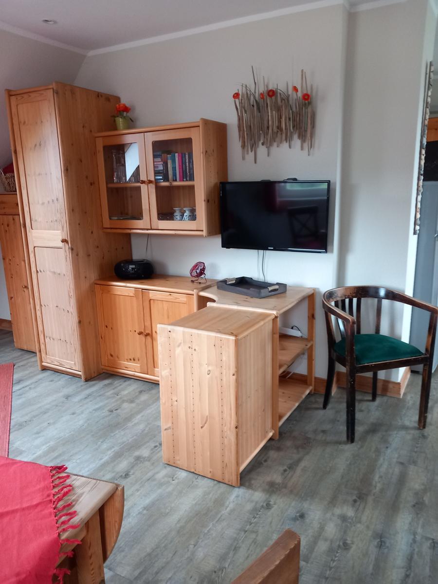 Wohnzimmer mit Holzmöbeln, Fernseher und Stuhl