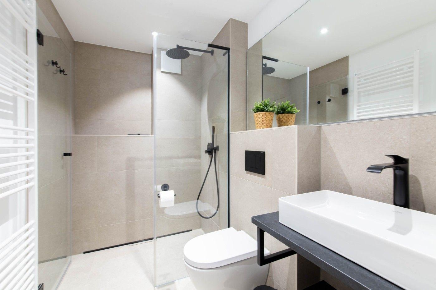 Moderne Badezimmer mit Dusche, Waschbecken und Toilette.