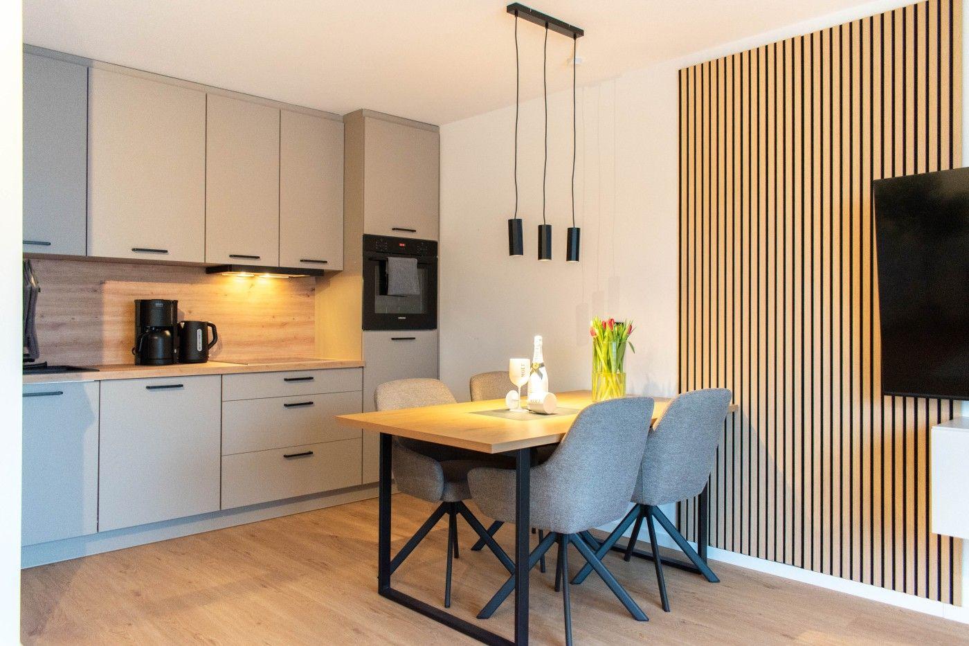 Küche mit Essbereich und Holzwand