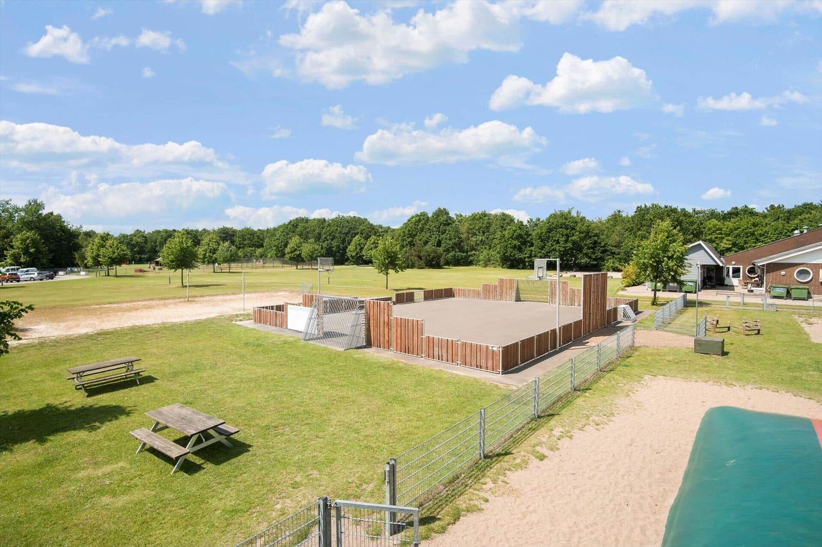 Large outdoor area with sand court, picnic tables, and play area.