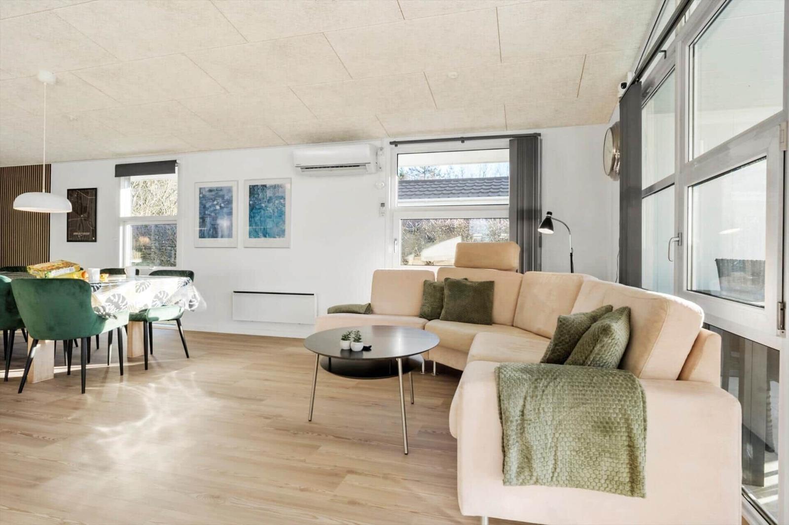 Living and dining area with sofa, table, and windows.