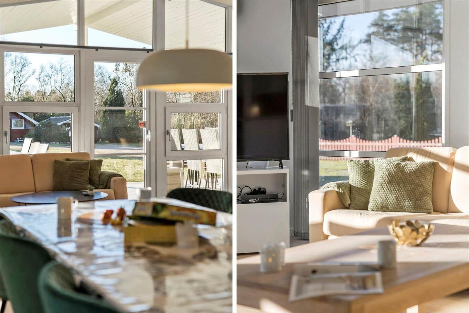 Living area with sofa, TV, and large window. Dining area with table and chairs.